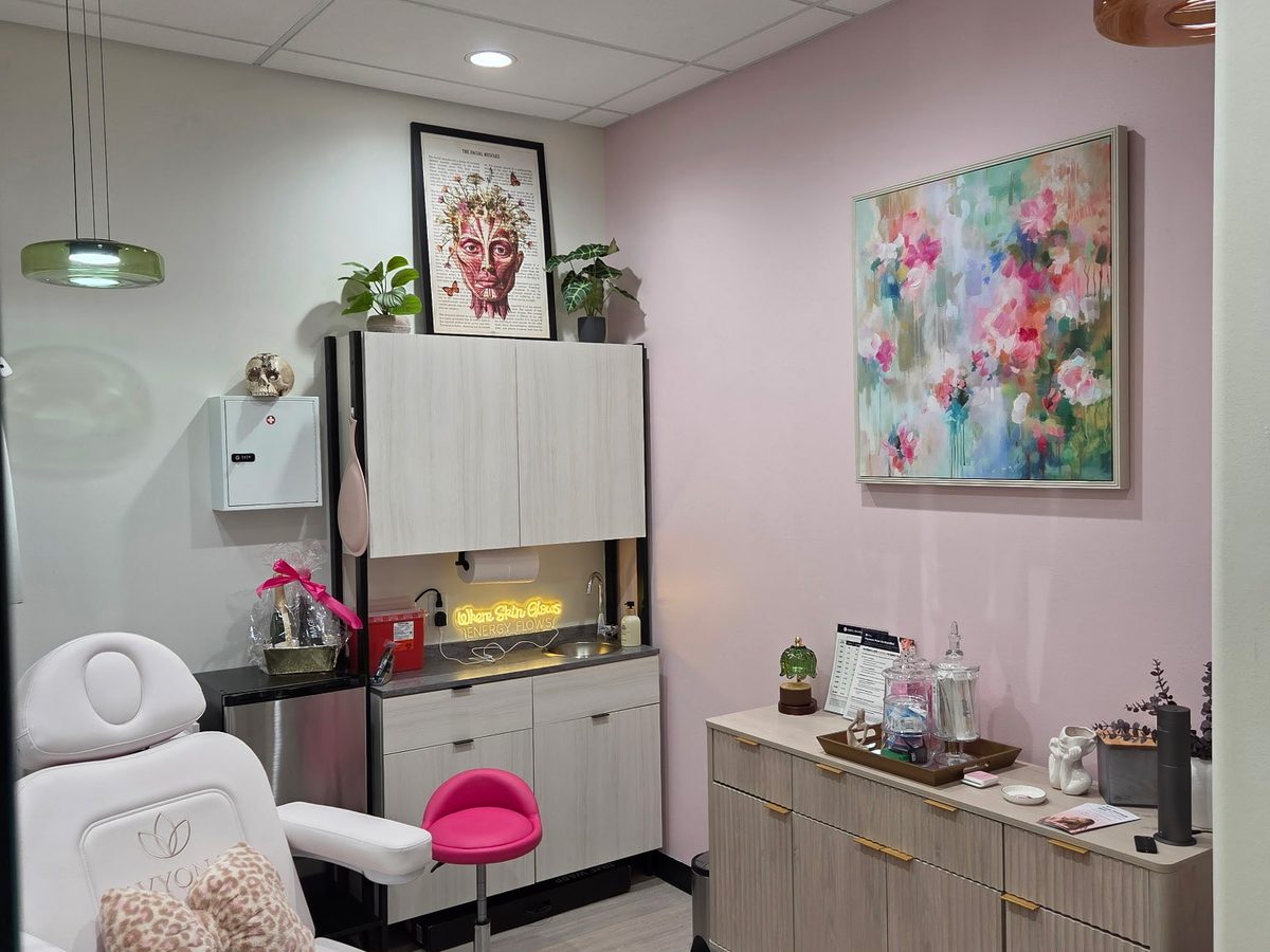 Infinite Glow treatment room with pink accent wall and floral artwork